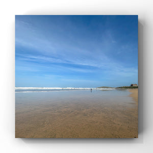 Deserted beach scene with clear blue sky and calm water