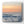 Sunset over the ocean with waves crashing on the shore