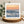 Sunset over the ocean with splashing wave, greetings card on a wooden coaster