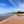 Beach scene with an old hotel on a headland under a blue sky