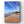 Beach scene with an old hotel on a headland under a blue sky