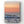 Pale orange and pink sunset with orange sun on the horizon. There is a splash of ocean wave in the foreground