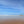 Beach scene with a vast expanse of sand, clear blue sky and calm water