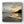 Beach scene with sunset reflected in wet sand and silhouetted headland.