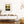 Modern living room with a wooden console table, framed marsh estuary sunrise artwork, and decorative items.