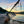 Buoy attached to a rope on a beach with a sunrise sky and boats in the background