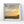 Framed artwork of a beach scene with sunset and birds, on a white wall.