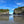 Bridge connecting two cliffs over a beach, reflected in wet sand, with clear blue sky