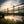 Wooden bridge over a body of water with a sunset in the background